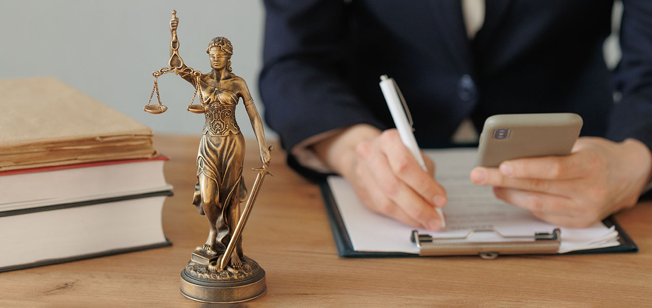 A lawyer making notes while looking at their phone.