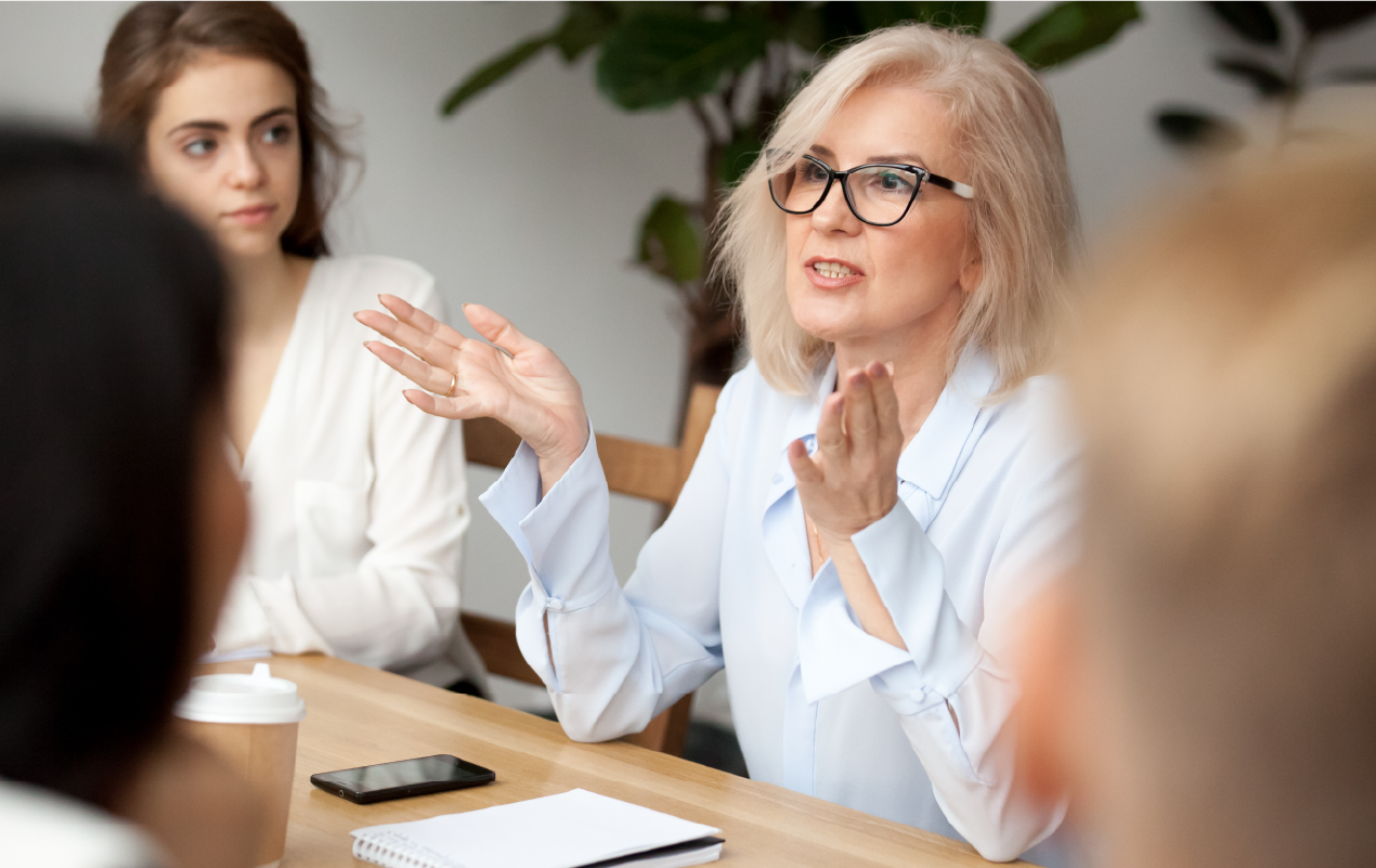 Middle-aged woman making a presentation in a meeting. 