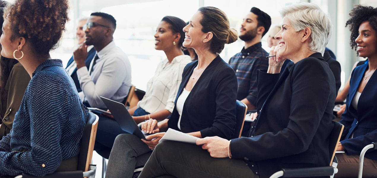 Une audience de gens d’affaires assistant à une conférence.